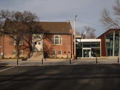 A red brick building with a classical entrance and a modern glass extension, featuring a sign above the entrance that reads "SOUTHERN ALBERTA ART GALLERY".
