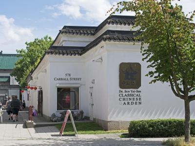 A white building with traditional Chinese architectural features, displaying a sign that reads "Dr. Sun Yat-Sen Classical Chinese Garden" and the address "578 Carrall Street".