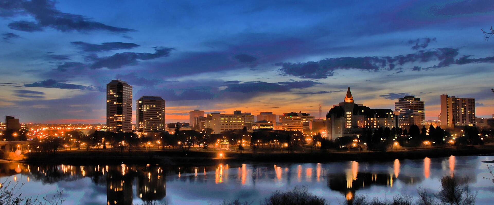 The Saskatoon skyline reflected in the South Saskatchewan River at dusk