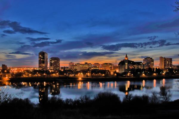 The Saskatoon skyline reflected in the South Saskatchewan River at dusk