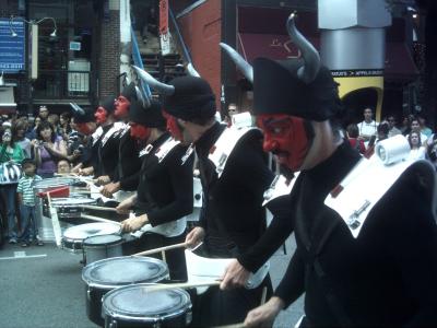 Costumed drummers in a Just for Laughs festival parade in Montreal