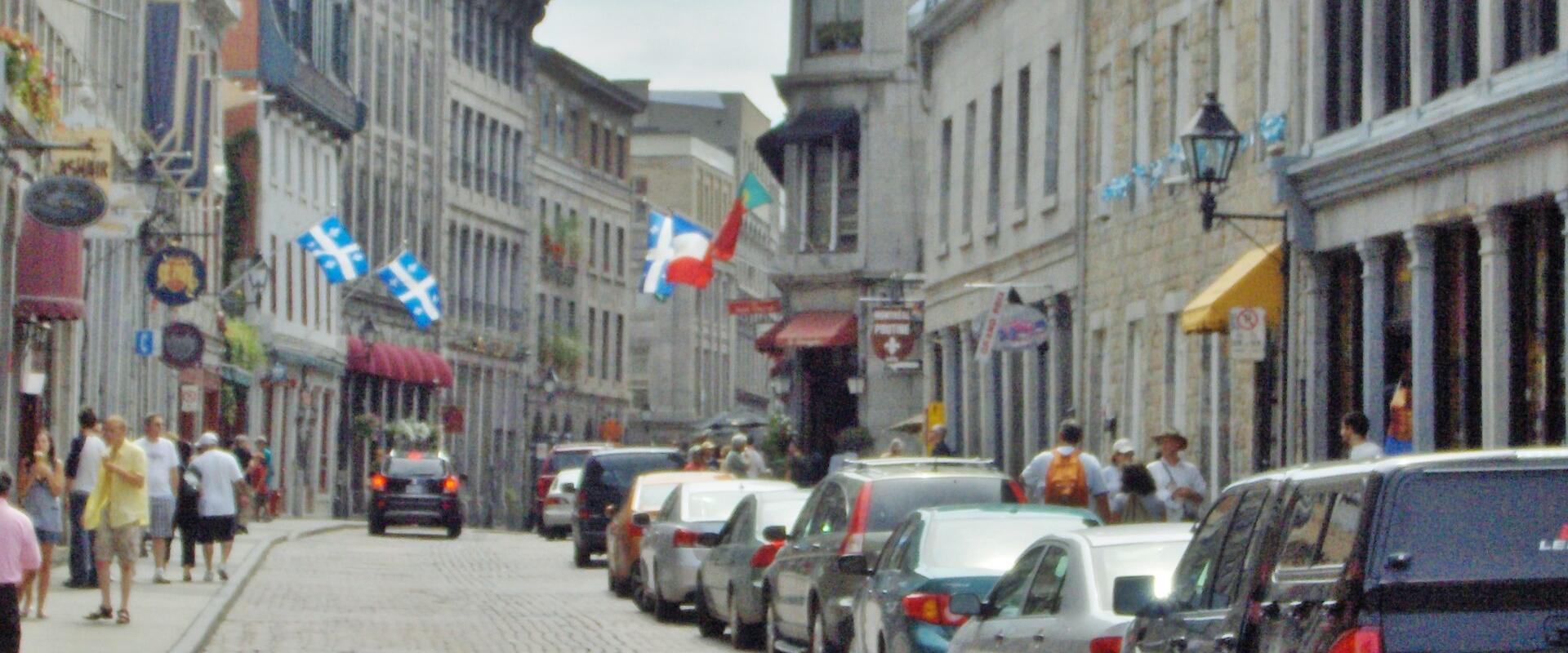 Stone buildings and flags along Rue Saint-Paul in Old Montreal