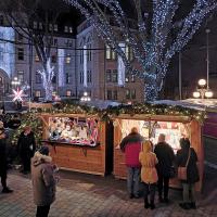 Wooden Christmas market stalls and lit trees in front of Québec City Hall at night