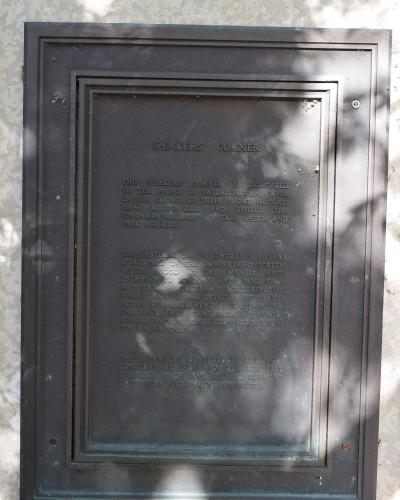 A close-up photograph of a bronze commemorative plaque mounted on a stone wall, titled "SPEAKERS' CORNER" and dedicated to the people of Saskatchewan.