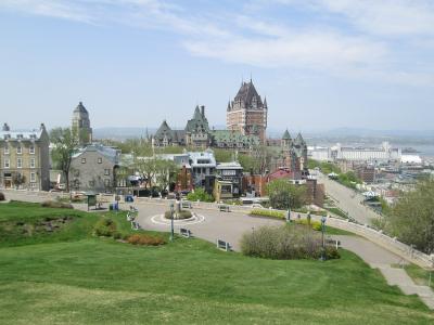 A high-angle view of the Quebec City skyline featuring the Château Frontenac, the Parliament Building, and the Dufferin Terrace, looking out over the St. Lawrence River.